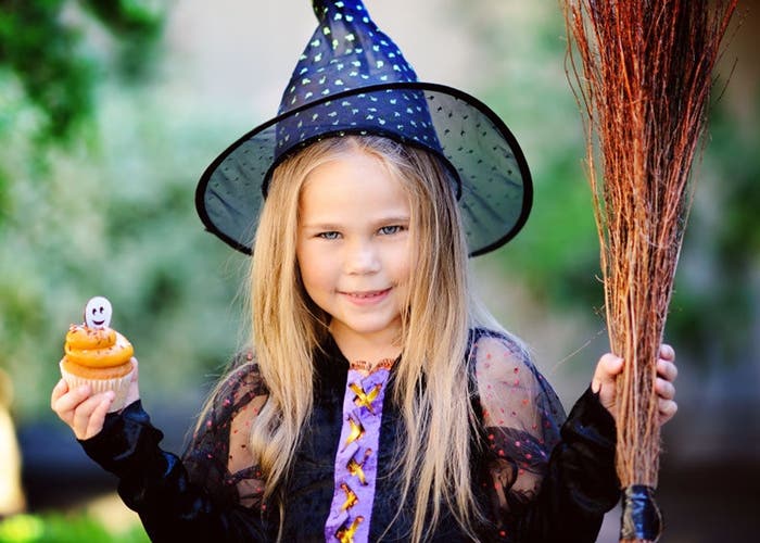 6 halloweenských receptů, které překvapí děti i dospělé 7 Dívka oblečená jako čarodějnice s halloween košíček