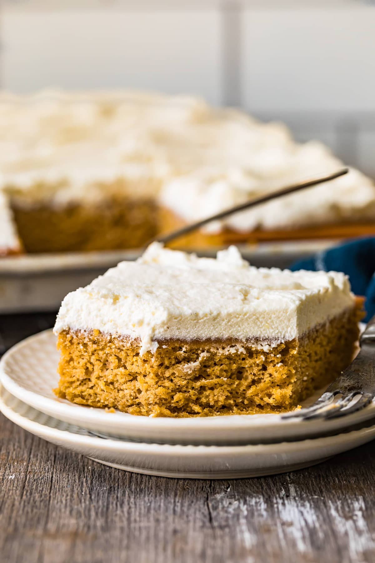 Dýňové tyčinky s krémovou polevou (nejlepší dýňový koláč) 11 Una barra de pastel de calabaza con glaseado en un plato blanco
